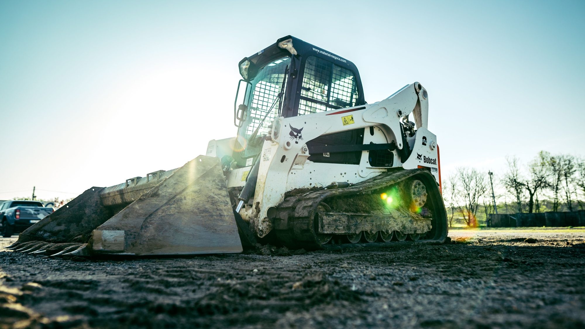 Track skid steer with bucket on graded ground